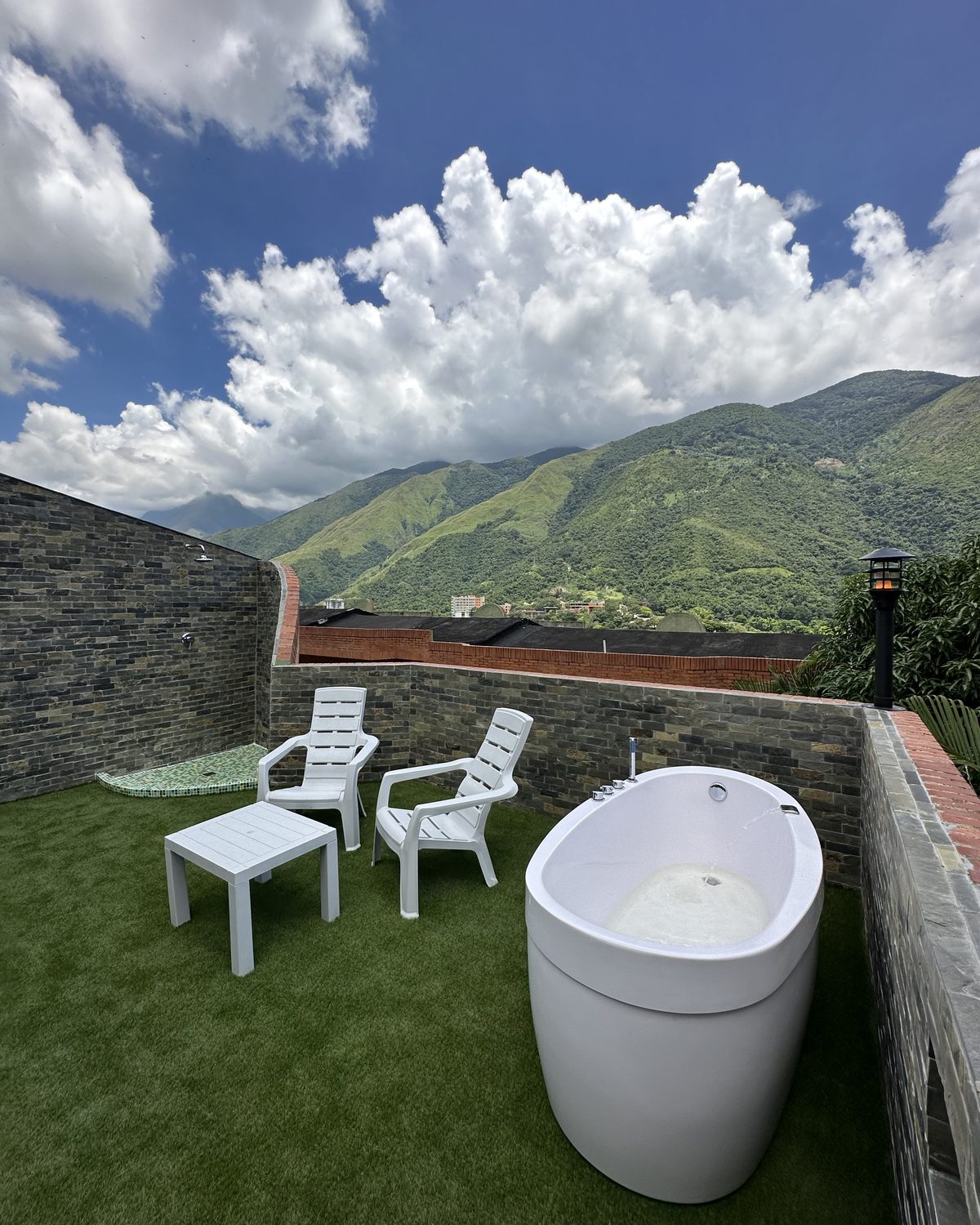 Terraza Premium: terraza con bañera al aire libre, sillas y vista a la montaña