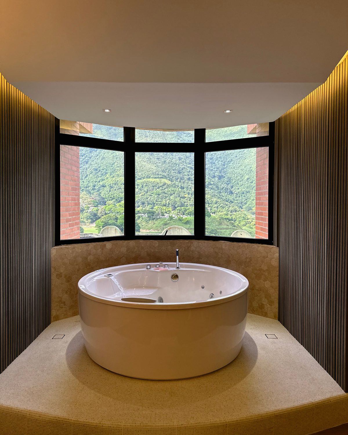 Zen Premium: jacuzzi redondo frente a la ventana con vista a la montaña
